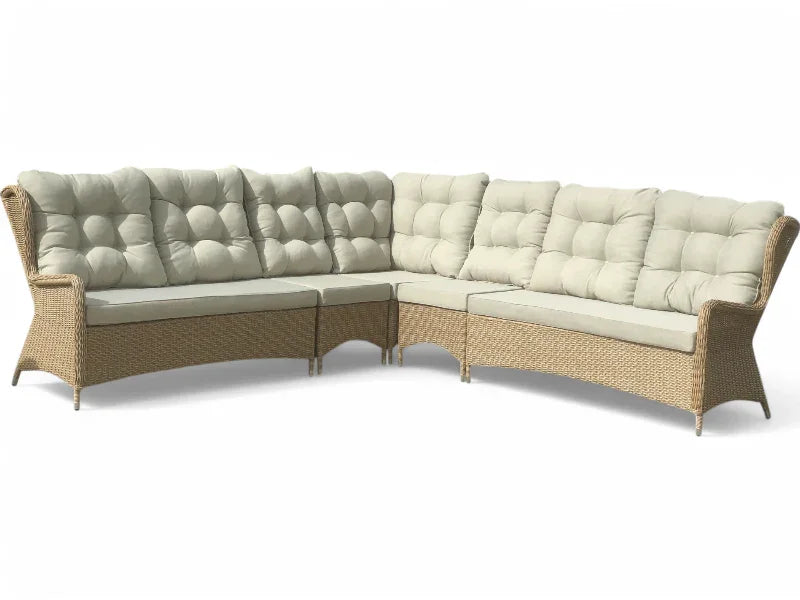 Stor hjørnesofa i håndflettet rattan med lyse hynder, ideel til terrasse eller have